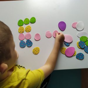 chłopiec układa piankowe jajka kolorowe